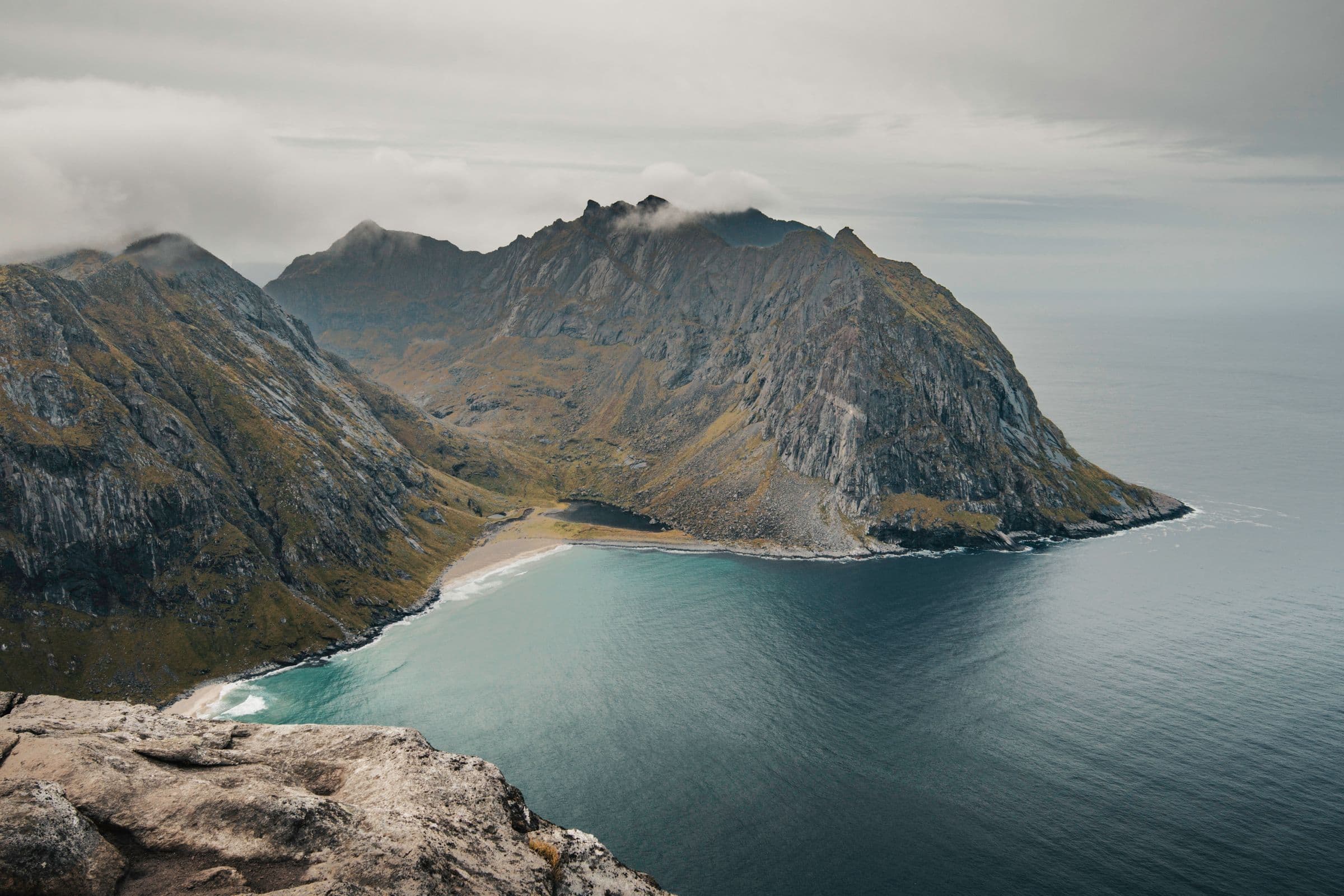 A quiet turquoise inlet beneath the mountains of the Norwegian coast